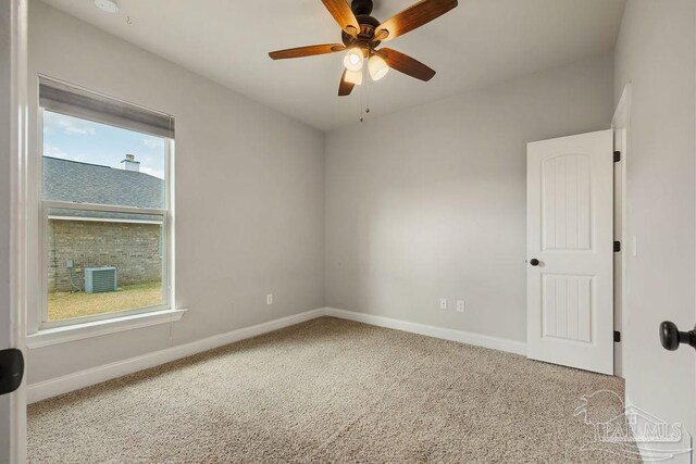 unfurnished room with carpet floors, a ceiling fan, and baseboards