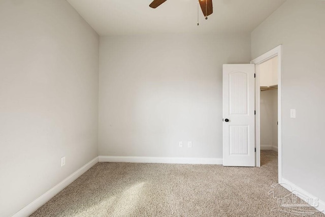 spare room featuring a ceiling fan, carpet floors, and baseboards