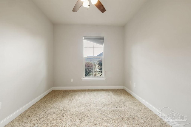 carpeted empty room with a ceiling fan and baseboards