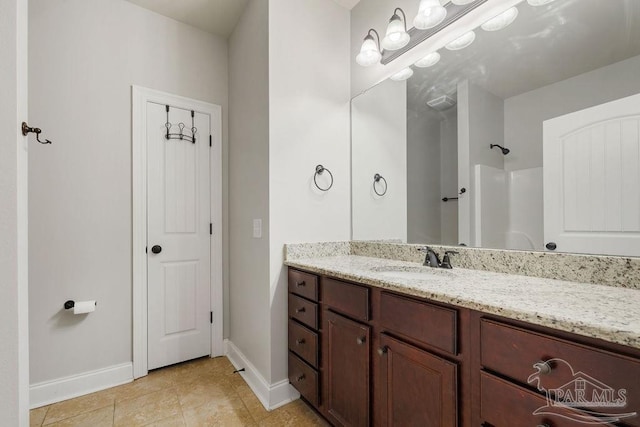 full bath with a shower, tile patterned flooring, vanity, and baseboards