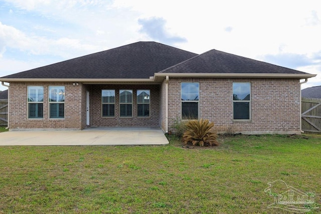 back of house with a yard, a shingled roof, a patio area, and brick siding