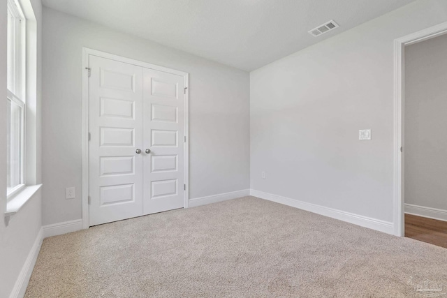 unfurnished bedroom featuring carpet floors and a closet