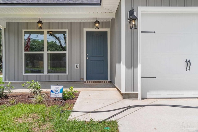 view of exterior entry featuring a garage and covered porch