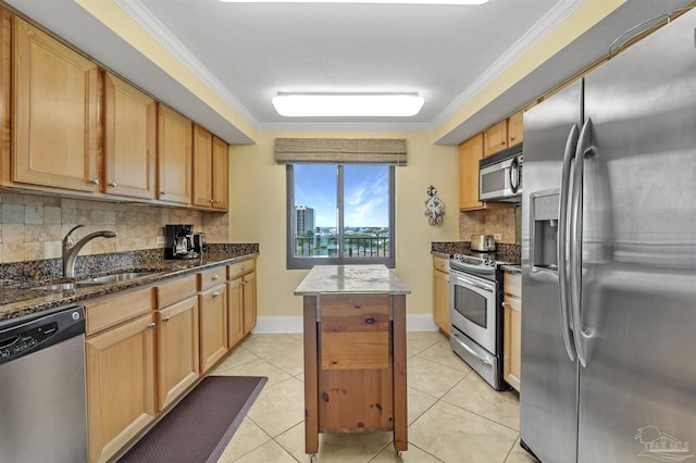 kitchen with stainless steel appliances, ornamental molding, light tile patterned flooring, a kitchen island, and a sink