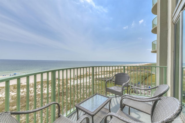 balcony featuring a beach view and a water view