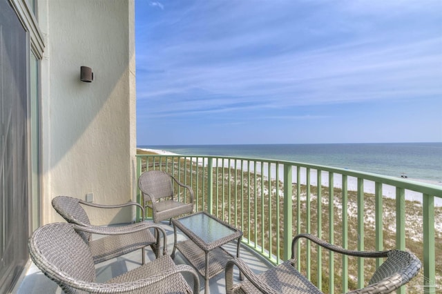 balcony with a water view and a view of the beach