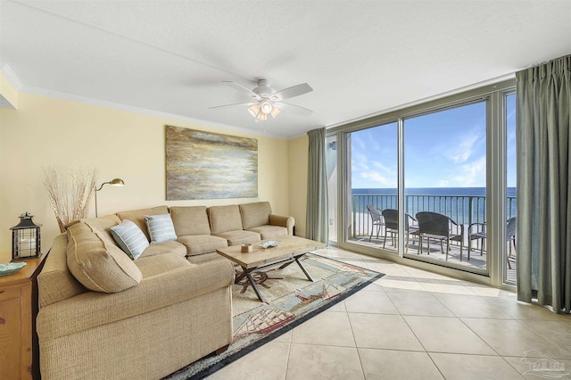 living room featuring a water view, ornamental molding, expansive windows, a ceiling fan, and light tile patterned flooring