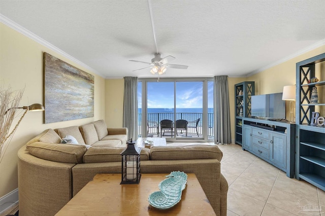 living room with a textured ceiling, light tile patterned floors, a ceiling fan, a wall of windows, and crown molding