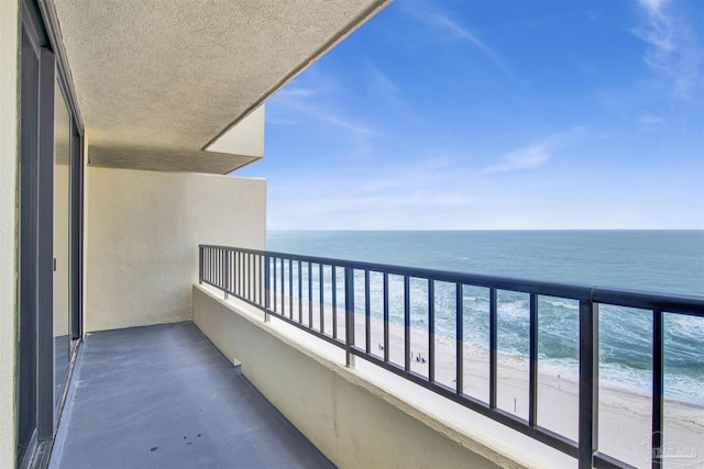 balcony featuring a view of the beach and a water view