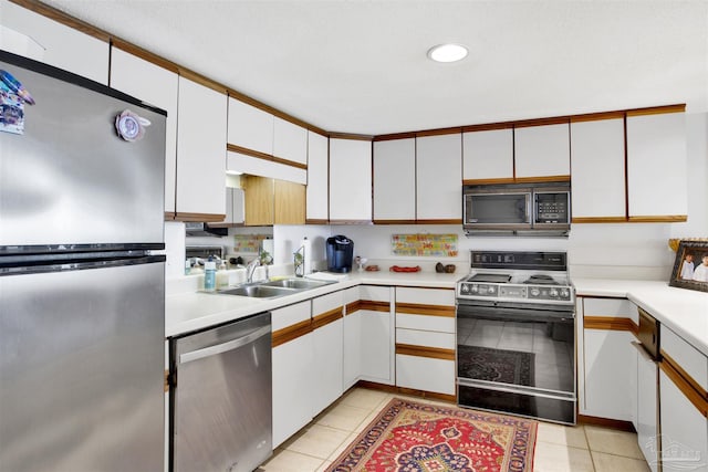 kitchen featuring white cabinetry, sink, light tile patterned floors, and appliances with stainless steel finishes