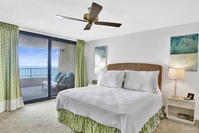 bedroom with a water view, carpet floors, access to outside, and ceiling fan