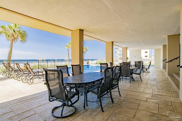 view of patio with a water view and a fenced in pool