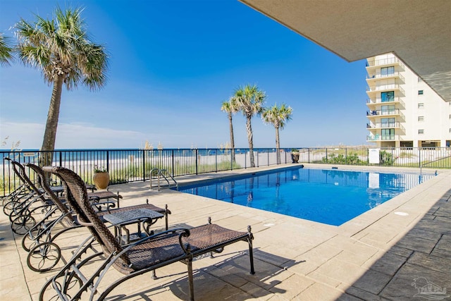 view of swimming pool featuring a patio area and a water view