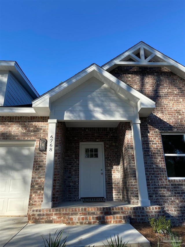 view of exterior entry with a porch and a garage