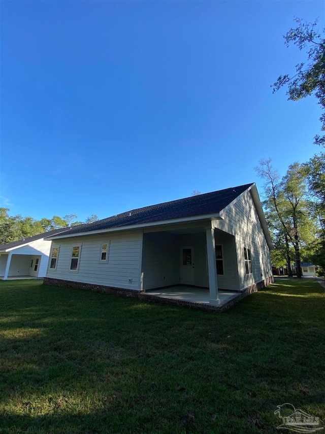 rear view of house featuring a patio area and a yard