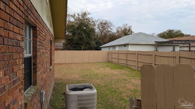 view of yard featuring cooling unit, a fenced backyard, and a pergola