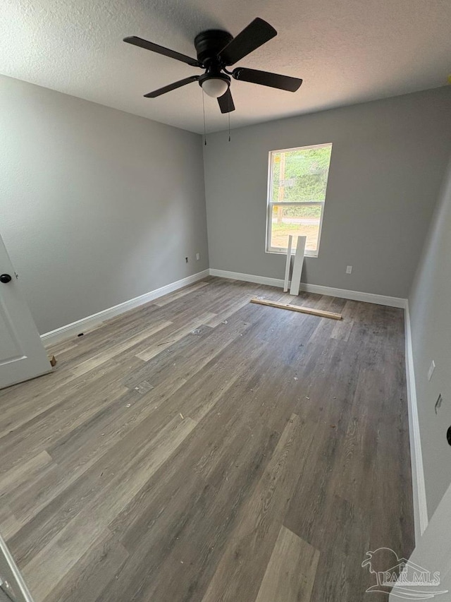 7147 Heath Rd, Milton, FL 32570 - unfurnished room featuring wood finished floors, a ceiling fan, a textured ceiling, and baseboards