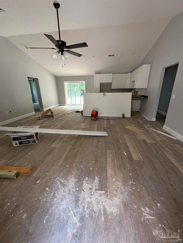 7147 Heath Rd, Milton, FL 32570 - unfurnished living room with vaulted ceiling, wood finished floors, ceiling fan, and baseboards
