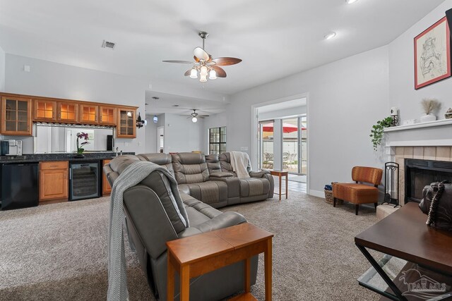 3849 Saber Tooth Cir, Gulf Breeze, FL 32563 - living room featuring beverage cooler, light colored carpet, a ceiling fan, bar with sink, and a tiled fireplace
