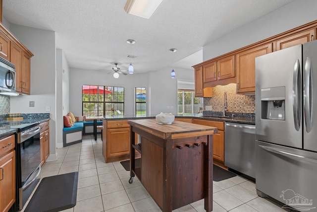 3849 Saber Tooth Cir, Gulf Breeze, FL 32563 - kitchen featuring appliances with stainless steel finishes, backsplash, butcher block countertops, a ceiling fan, and light tile patterned flooring