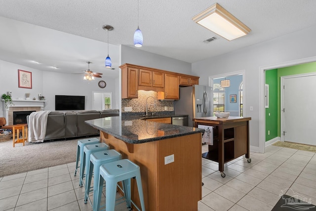 3849 Saber Tooth Cir, Gulf Breeze, FL 32563 - kitchen featuring light tile patterned floors, ceiling fan, a kitchen breakfast bar, tasteful backsplash, and brown cabinets