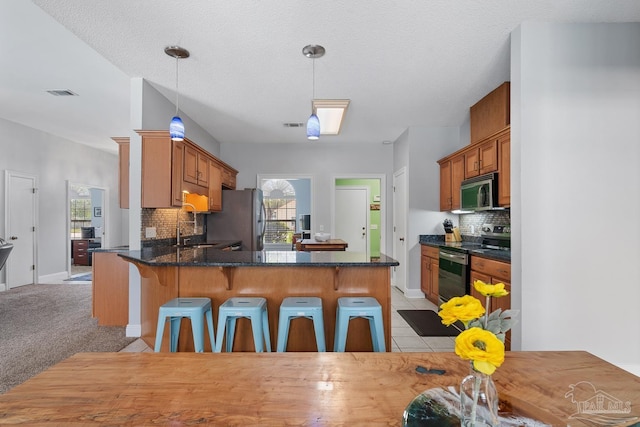 3849 Saber Tooth Cir, Gulf Breeze, FL 32563 - kitchen featuring stainless steel appliances, a peninsula, tasteful backsplash, and a kitchen bar