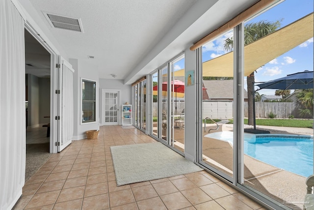 3849 Saber Tooth Cir, Gulf Breeze, FL 32563 - unfurnished sunroom with tile patterned flooring and a textured ceiling