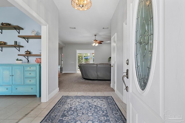 3849 Saber Tooth Cir, Gulf Breeze, FL 32563 - foyer entrance with light tile patterned floors, light colored carpet, ceiling fan, and a chandelier
