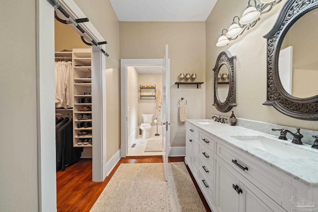 bathroom with hardwood / wood-style floors, vanity, and toilet