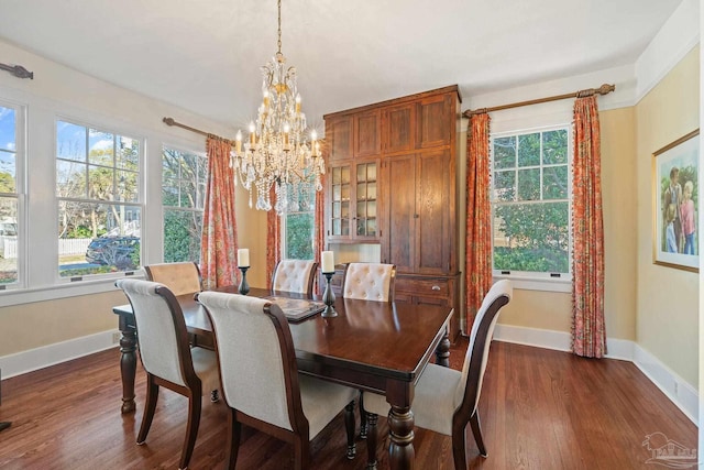 dining area with dark hardwood / wood-style flooring, a chandelier, and plenty of natural light