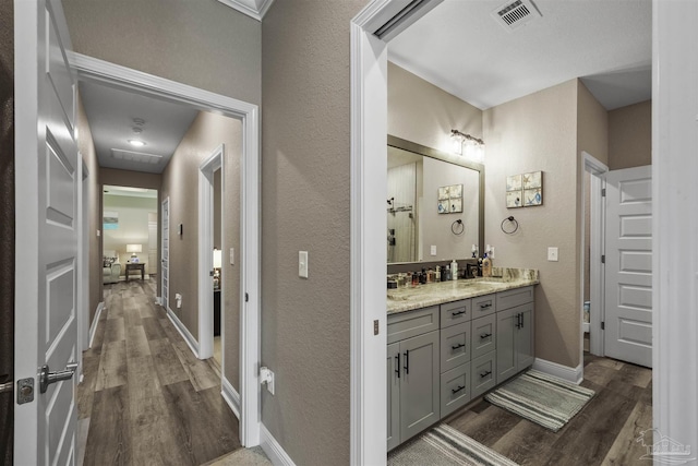 12561 Lillian Hwy, Pensacola, FL 32506 - bathroom featuring wood finished floors, double vanity, baseboards, and a textured wall