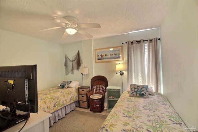 bedroom with ceiling fan, light tile patterned flooring, and a textured ceiling