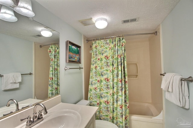 full bathroom with vanity, toilet, a textured ceiling, and shower / bath combo