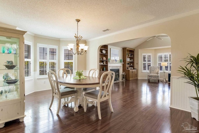 dining room with visible vents, arched walkways, a healthy amount of sunlight, and wainscoting