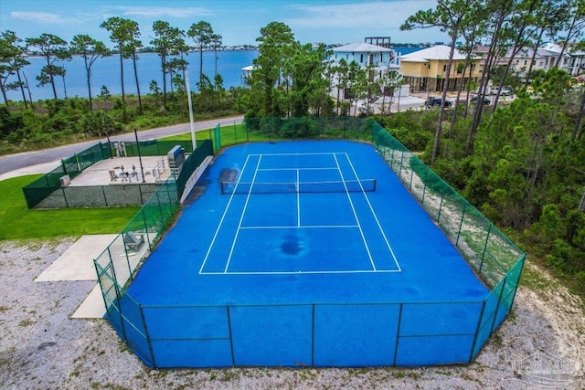 view of tennis court with a water view