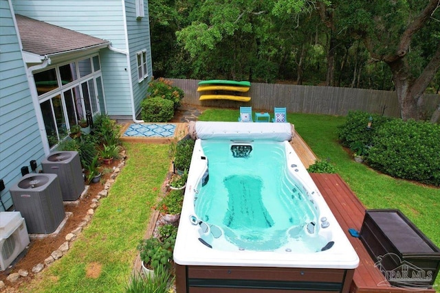 view of swimming pool featuring cooling unit and a yard