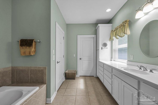 bathroom with tiled bath, tile patterned flooring, and vanity