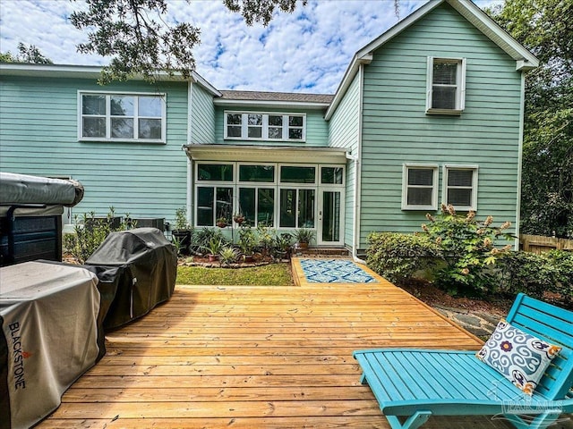 rear view of house with a wooden deck and a sunroom