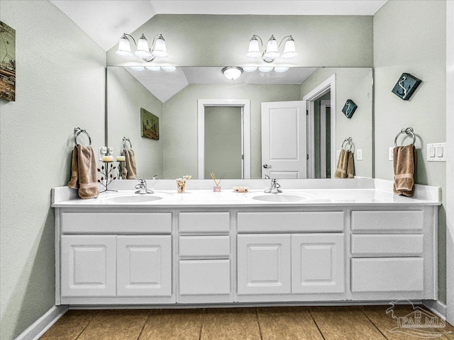 bathroom with tile patterned floors, lofted ceiling, and vanity