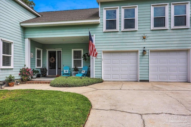 view of front of house with a garage, covered porch, and a front lawn