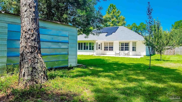7543 Loop St, Navarre, FL 32566 - rear view of house with roof mounted solar panels, a patio, and a storage shed