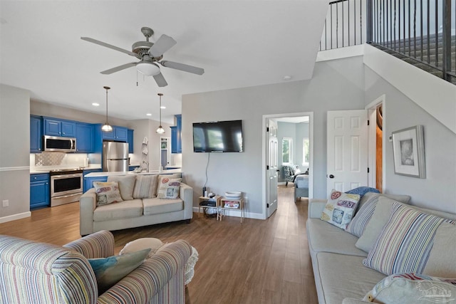 living room featuring dark hardwood / wood-style flooring and ceiling fan