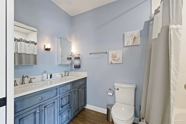 bathroom featuring hardwood / wood-style floors, a shower with curtain, vanity, and toilet