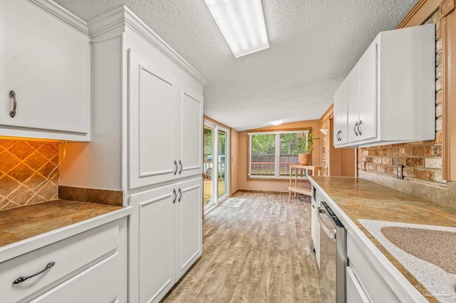 2931 Pine Forest Rd, Cantonment, FL 32533 - kitchen featuring a textured ceiling, dishwasher, light wood-style flooring, white cabinets, and vaulted ceiling