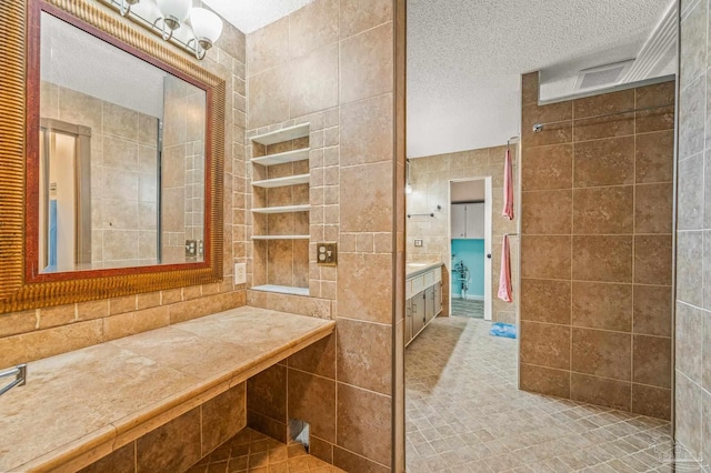2931 Pine Forest Rd, Cantonment, FL 32533 - bathroom with tile walls, a textured ceiling, vanity, and tiled shower