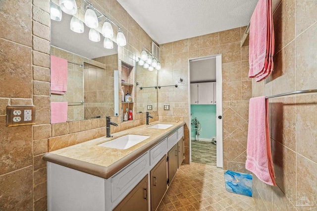 2931 Pine Forest Rd, Cantonment, FL 32533 - bathroom featuring tile walls, double vanity, tile patterned floors, and a textured ceiling
