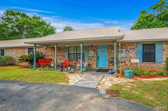 2931 Pine Forest Rd, Cantonment, FL 32533 - ranch-style house featuring a porch, metal roof, and brick siding