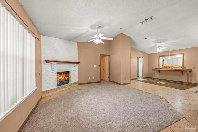 2931 Pine Forest Rd, Cantonment, FL 32533 - unfurnished living room featuring a ceiling fan, lofted ceiling, tile patterned floors, a brick fireplace, and baseboards