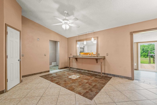 2931 Pine Forest Rd, Cantonment, FL 32533 - entrance foyer with ceiling fan, vaulted ceiling, light tile patterned floors, a textured ceiling, and baseboards