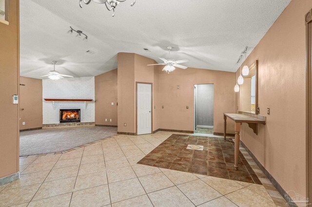 2931 Pine Forest Rd, Cantonment, FL 32533 - tiled foyer entrance with ceiling fan, vaulted ceiling, a brick fireplace, a textured ceiling, and baseboards